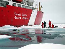 Two SCUBA divers prepare to descend below the ice to search for life