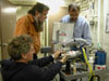 With the aid of Dale Chayes and Eben Franks, ROV operator, Jerry Caba, repairs the fiber optic rotary joint.