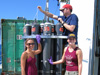 Monica Heintz and Christine Desautels work with research technician Nathan Buck to extract water samples.