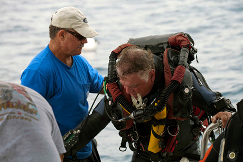 Brian lending Paul a hand getting back into the boat.