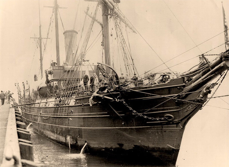 Close-up of Bear mooring to a pier showing her hull and sail rig. 