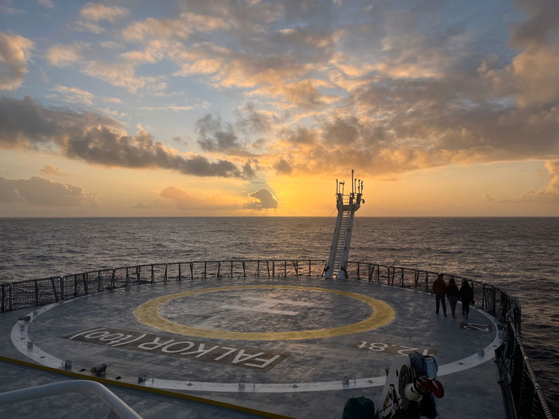 The sun setting beneath the horizon as seen from Research Vessel Falkor (too) (helicopter deck in the foreground) during the expedition that hosted the Exploring Deep-Sea Methane Seeps Along the Chile Margin project.